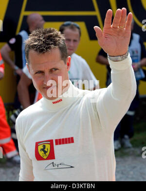 (Dpa) - Tedesco pilota di Formula Uno Michael Schumacher della Ferrari onde ai suoi fan dopo la seconda sessione di formazione presso il circuito di Formula Uno a Monza, Italia, venerdì 02 settembre 2005. Schumacher span durante la fase di esecuzione pratica. Il Gran Premio d'Italia si svolgerà qui di domenica 04 settembre. Foto: Gero Breloer Foto Stock