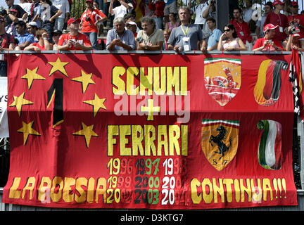 (Dpa) - ventilatori di tedesco pilota di Formula Uno Michael Schumacher in Ferrari di visualizzare un banner di lettura "Schumi e Ferrari - il poema continua' prima del Gran Premio d'Italia in occasione del Gran Premio d'Italia via Italia a Monza, domenica 04 settembre 2005. Foto: Gero Breloer Foto Stock