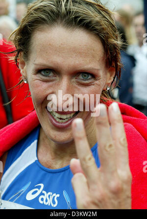 (Dpa) - Whilde indicando con le dita la sua terza vittoria in sucession, tedesco Claudia Dreher sorride alla telecamera dopo la sua vittoria alla nona maratona di Ford a Colonia, Germania, Domenica, 11 settembre 2005. Dreher sincronizzata di 2:31:43. Foto: Felix Heyder Foto Stock