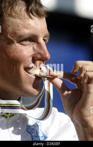 (Dpa) - Russo ciclista Michael Ignatiev bit la sua medaglia d oro dopo aver vinto l'uomo singolo time trial in gara il sotto 23 classe al Campionato mondiale di ciclismo di Madrid in Spagna, mercoledì, 21 settembre 2005. Il tour ha coperto una distanza di 37,9 chilometri. Foto: Bernd Thissen Foto Stock