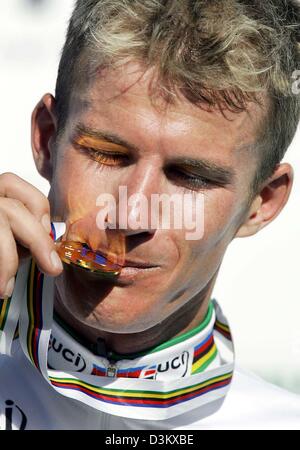 (Dpa) - Australian cycling pro Michael Rogers del Team Quick Step morde la sua medaglia d oro dopo aver vinto l'uomo singolo time trial gara durante la Worldchampionship nel ciclismo in Spagna a Madrid, giovedì, 22 settembre 2005. Rogers è riuscito a difendere il suo titolo che ha vinto l'anno precedente. Foto: Vincent Jannink Foto Stock