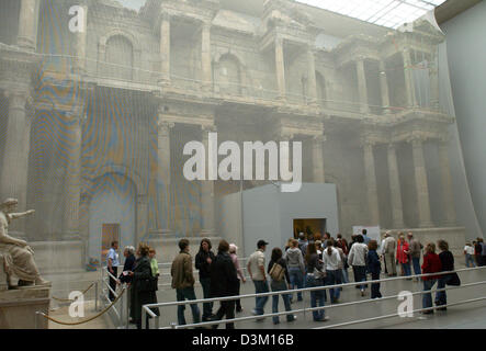 (Dpa) - visitatori stand nella grande sala espositiva di fronte all'antica 'mercato gate di Mileto', che è coperto da una rete all'Pergamon-Museum a Berlino, Mercoledì, 19 ottobre 2005. La porta, che è di circa 1.800 anni, è considerato uno dei più in pericolo strutture antiche sul cosiddetto "Isola dei Musei di Berlino. La porta sarà parzialmente preso in giù e memorizzati Foto Stock