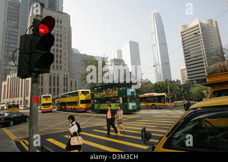 (Dpa) file - I pedoni a piedi attraverso una zebra crossing in Hong Kong, Cina, 28 ottobre 2004. In alto (2a da R) è il cosiddetto Centro Finanziario Internazionale, che segna con un altezza di 415 metri il più alto edificio della città. Hong Kong, che ha una popolazione di 7,5 milioni di euro, era stata sotto amministrazione britannica fino a diventare la regione amministrativa speciale di Hong Kong Reg Foto Stock