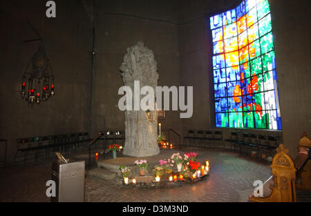 (Dpa) - Vista delle candele e fiori nella parte anteriore di una colonna, che ritrae Maria e il Bambino Gesù, all'interno della chiesa di pellegrinaggio 'Mary, Regina di pace in Velbert-Neviges, Germania, 03 novembre 2005. A causa del tetto è unica forma la Chiesa ha la forma esterna appare come una tenda. Per più di 320 anni le persone sono state pregando per la Santa Maria Madre di Dio in Neviges. Il nuovo pellegrinaggio c Foto Stock