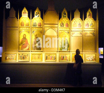 (Dpa) - Un visitatore guarda le tabelle religiosa di una ricostruzione di un altare maggiore dal 1325/26, alla fiera "Geschichten auf Gold - Bilderzaehlungen in der fruehen italienischen Malerei' (storie su oro - Foto di storie in primi dipinti italiani) di Berlino, 08 novembre 2005. 36 Conserve di tabelle, che erano originariamente collocati presso la chiesa di Santa Croce a Firenze, Italia, h Foto Stock