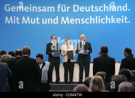 (Dpa) - La figura mostra (da L a R) DOCUP presidente Matthias Platzeck, CDU presidentessa Angela Merkel e il presidente CSU Stoiber con il firmato accordo di coalizione a Berlino, Germania, venerdì 18 novembre 2005. SPD e CDU/CSU concordato di leadership nei precedenti colloqui sulla seconda grande coalizione nella storia dell'Repulic federale di Germania. Foto: Peer Grimm Foto Stock