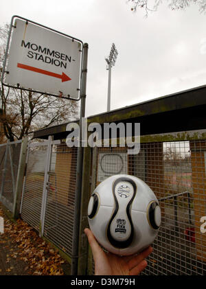 (Dpa) - Una mano afferra la palla ufficiale per il 2006 FIFA Mondiali di Calcio in Germania a fronte di un ingresso di Mommsen stadium di Berlino, Germania, 12 dicembre 2005. Team nazionale tedesco Klinsman pullman e i giocatori della nazionale tedesca di calcio hanno con il telecomando stadium vicino alla fiera una seconda massa di formazione nella capitale tedesca. Il team farà pratica nel Mommse Foto Stock