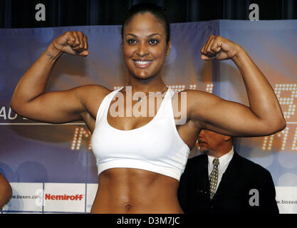 (Dpa) - US boxing campione del mondo in super middleweight Laila Ali si flette la sua bicepts e sorrisi come essa si erge sulla scala durante la pesa pubblica a Berlino, Venerdì, 16 dicembre 2005. Ali è di andare a combattere il suo challenger boxer svedese Asa Sandell nel titolo bout Sabato, 17 dicembre 2005. Foto: Steffen Kugler Foto Stock