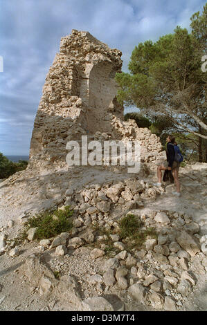 (Dpa) - Un turista guarda la rovina della Torre Embucada torre di avvistamento a Punta de Capdepera a est di Mallorca, Spagna, 28 giugno 2004. Un totale di 85 di queste torri di avvistamento che sono chiamati 'Talaies', esistevano originariamente su tutta l'isola. Nel corso del xvii secolo furono utilizzati come protezione contro gli attacchi dei pirati. Foto: Thorsten Lang Foto Stock