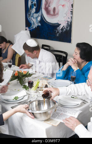 Famiglia seduti attorno a un tavolo per una festa ebraica pasto sulla Pasqua (traslitterato come Pesach o Pesah) Foto Stock