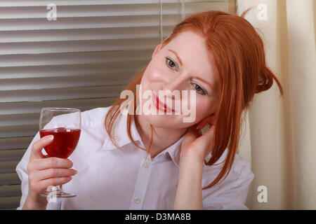 Giovane donna di bere da solo a casa Foto Stock