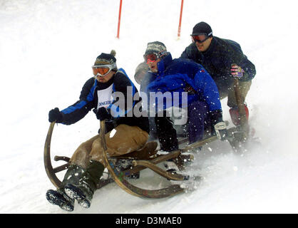 (Dpa) - spericolati uomini corsa in discesa su una slitta alla montagna locale a Garmisch-Partenkirchen, in Germania, venerdì 06 gennaio 2006. Squadre di quattro competere in gara a cavallo di legno tradizionali slittini con lunghi a forma di corno guide. Foto: Frank Maechler Foto Stock