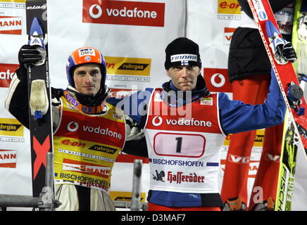 (Dpa) - sci ceco Jakub ponticello Janda (L) gratulates i suoi compagni di ponticello di sci finlandese Janne Ahonen (R) stand gli uni accanto agli altri e wave dopo il round finale sul Paul Ausserleitner ski jump al 54th FIS quattro Hill nel torneo di Bischofshofen, Austria, Venerdì, 06 gennaio 2006. Per la prima volta nella storia del concorso due ponticelli di sci sono la condivisione della vittoria assoluta. Foto Stock