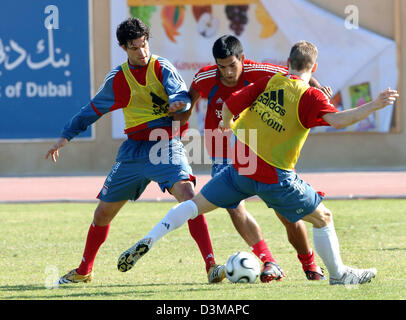 (Dpa) - Michael Ballack, Julio Dos Santos e Bastian SCHWEINSTEIGER (L-R) della Bundesliga tedesca club FC Bayern Monaco si contendono la palla durante una partita corsi di formazione presso la sede del Al Wasl Football Club a Dubai, Emirati arabi uniti, martedì 10 gennaio 2006. Il team soggiorni a Dubai per una decina di giorni di training camp. Foto: Bernd Weissbrod Foto Stock