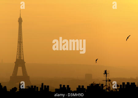 Torre Eiffel vista da Montmartre sul tramonto. Sagoma scura della torre e tetti Parigini contro il naturalmente red sky Foto Stock