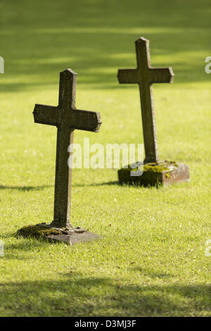 Due antiche tombe con croci cristiane sull'erba verde del cimitero Foto Stock