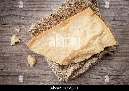 Porzione di parmigiano a sfondo di legno Foto Stock