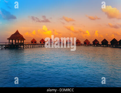 Case su palafitte sull'acqua al momento del tramonto Foto Stock