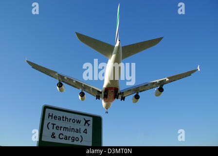 L'aereo Emirates Airbus A380 atterra all'aeroporto Heathrow di Londra sul cartello con scritto Heathrow Terminal 4 & Cargo Foto Stock