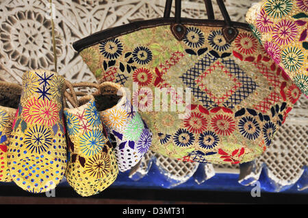 Rafia o paglia tessuta e cestelli ricamato in vendita appeso a una fase di stallo all'interno della medina o souk, Marrakech, Marocco Foto Stock