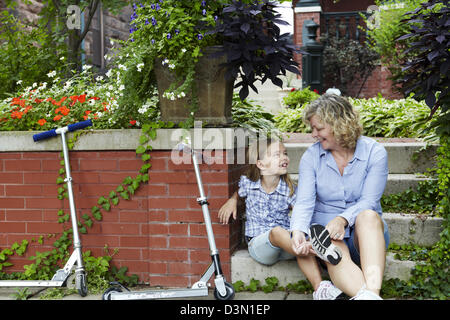 Legatura a Mom di mia figlia scarpe prima sella scooter Foto Stock