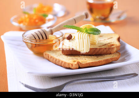 La prima colazione - Fette biscottate, burro, miele e marmellata Foto Stock
