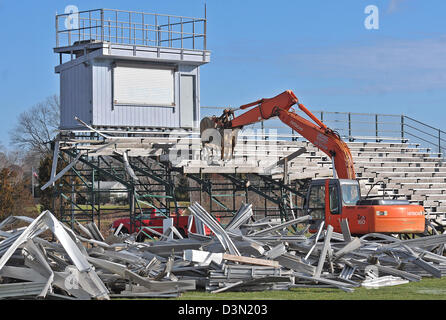 Un wrecker abbatte le gradinate in uno stadio di calcio in Madison CT USA come la città si prepara a costruire una nuova. Foto Stock