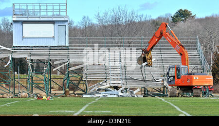 Un wrecker abbatte le gradinate in uno stadio di calcio in Madison CT USA come la città si prepara a costruire una nuova. Foto Stock