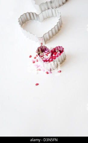 A forma di cuore ad cookie cutter e torta spruzza o decorazioni per la cottura Foto Stock