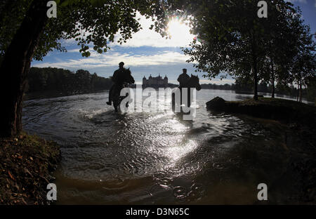 Moritzburg, Germania, silhouette di cavalli e cavalieri nel lago di fronte alla Schloss Moritzburg Foto Stock