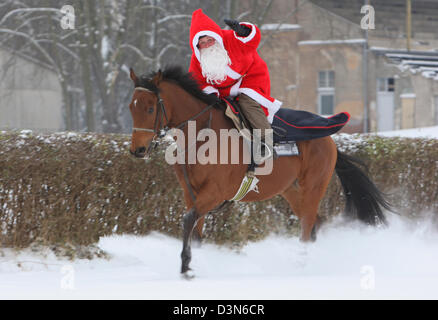 Hoppegarten, Germania, Santa Claus in sella a un cavallo attraverso la neve Foto Stock