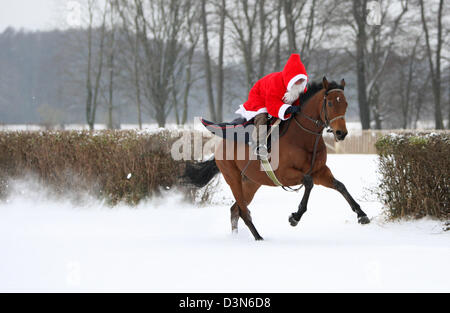 Hoppegarten, Germania, Santa Claus in sella a un cavallo attraverso la neve Foto Stock