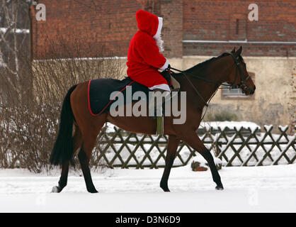 Hoppegarten, Germania, a Santa Claus in sella a un cavallo attraverso la neve Foto Stock