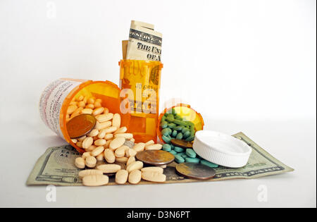 Una fotografia della medicina di prescrizione di bottiglie, pillole e denaro che rappresenta il costo elevato della sanità su uno sfondo bianco. Foto Stock
