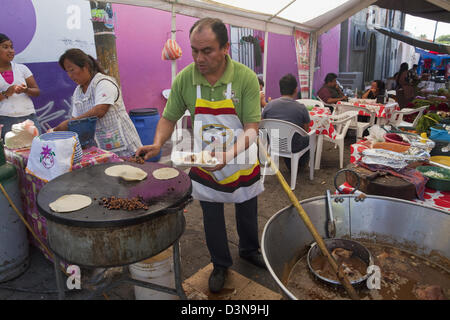 L uomo e la donna la preparazione di tacos in fuori il cafe in Villa de Etla mercato, Oaxaca, Messico. Foto Stock