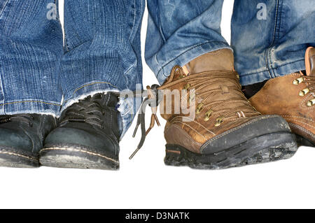 Due coppie di maschio e femmina gambe in jeans con stivali attaccato a ciascun altro Laces - amare per sempre Foto Stock