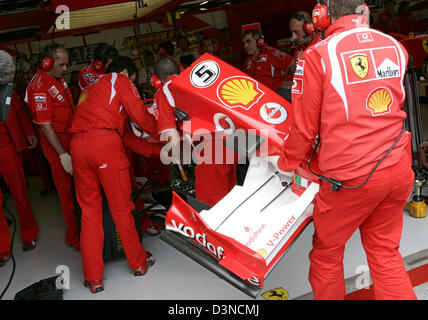 I meccanici della scuderia Ferrari il lavoro sulla parte anteriore del tedesco pilota di Formula Uno Michael Schumacher racing car durante la sessione di formazione presso la Albert Park Street circuito di Melbourne, Australia, venerdì 31 marzo 2006. La Australian Formula One Grand Prix avviene qui di domenica 02 aprile. Foto: Rainer Jensen Foto Stock