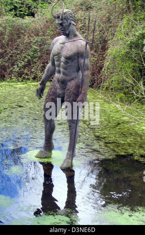 (Dpa) file - un diavolo cornuto della statua con un tridente sorge da una piscina sul sentiero che conduce verso il diavolo il foro nel nord del canale isola di Jersey, Regno Unito, 16 aprile 2005. Il diavolo il foro è un 30 m profondo canyon che si apre verso il mare. Con alta marea o forti venti da nord la nebulizzazione viene spinto verso l'alto fino alla diga. Foto: Juergen Darmstaedter Foto Stock