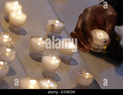 Una di carnagione scura uomo detiene una candela in un servizio di chiesa dedicata alla vittima di un tentato omicidio di stampo razzista a Friedenskirche (lit. Chiesa della Pace a Potsdam, in Germania, mercoledì 19 aprile 2006. Circa 300 persone hanno preso parte ad esso. Molte candele sono state accese e poste in righe sul pavimento come un segno di compassione e di solidarietà con la famiglia del 37 enne tedesco di o etiope Foto Stock