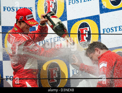 Il tedesco pilota di Formula Uno Michael Schumacher (Ferrari) e la sua testa del team francese Jean Todt (R) spray con chapagne sul podio dopo il Gran Premio di San Marino presso la pista di Imola, Italia, domenica 23 aprile 2006. Foto: Gero Breloer Foto Stock