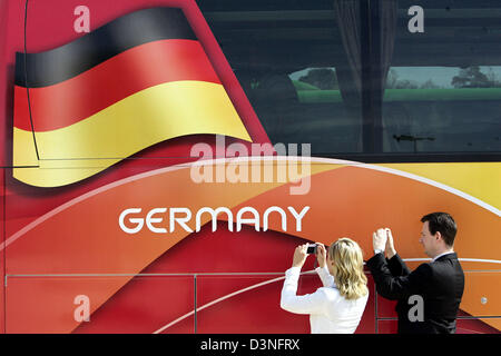 Due tifosi di calcio foto di uno dei team di 32 autobus per la Coppa del Mondo FIFA 2006 onda alla consegna ufficiale a Francoforte in Germania, giovedì 4 maggio 2006. Gli autobus sono verniciati nei colori nazionali. Sponsor ufficiale Hyundai ha consegnato anche una flotta di auto per la Coppa del Mondo FIFA 2006 Comitato di organizzazione. Foto:Frank può Foto Stock