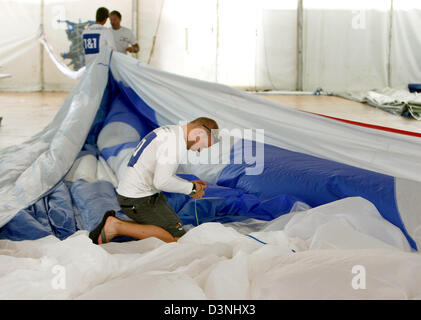 Un United Internet Team Germany membro di equipaggio è occupato imballaggio i 510 metri di piazza grande vela della barchetta tedesca GER 72 a Valencia in Spagna, giovedì 18 maggio 2006. La tre giorni di Coppa America 2007 pre-regata "Fleetrace-Serie atto 11' beginns venerdì pomeriggio. Foto: Maurizio Gambarini (ATTENZIONE: la pubblicazione solo per scopi editoriali) Foto Stock