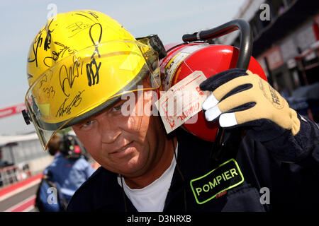 La foto mostra un canadese vigile del fuoco con il suo casco firmato dai piloti di Formula Uno in pit lane del Gilles Villeneuve race track a Montreal, Canada, Domenica, 25 giugno 2006. Foto: Jens Buettner Foto Stock