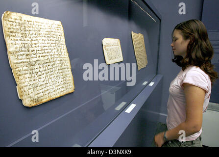 Un visitatore esamina vecchia pergamena con la calligrafia islamica nel Pergamon Museum di Berlino in Germania, giovedì, 13 luglio 2006. Il London gallerista Sam Fogg presenta una raccolta di suoi calligraphies e prenota luminarie, la primogenita arte del Corano pittura, su invito del museo. Il 'Masterpieces della calligrafia islamica' può essere visto dal 15 luglio al 31 agosto 2006. Foto: Marcel Foto Stock