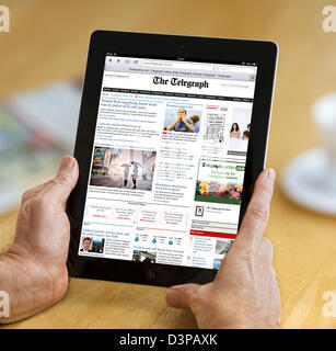 La lettura della edizione internet del telegrafo quotidiano online su una quarta generazione di iPad, REGNO UNITO Foto Stock