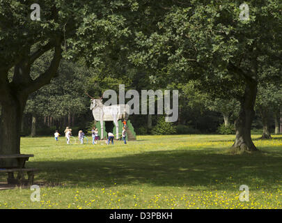 Bambini che giocano in legno la figura di un cervo a Thetford Forest picnic Foto Stock