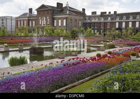 I colorati giardini di fiori nella parte posteriore del Kensington Palace. Multi colorati fiori di primavera decorano la piscina presso il palazzo Foto Stock