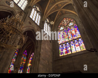 Votive in vetro colorato e candelabri. Una vista dell'abside laterale di questa magnifica chiesa del diciannovesimo secolo. Foto Stock