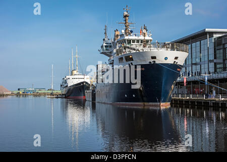 Northern Lighthouse Board gara multifunzione NLV Pharos ormeggiati Western Harbour Leith Docks Edimburgo con Britannia dietro Foto Stock