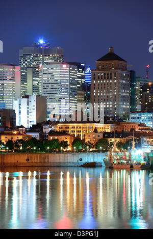 Montreal oltre il fiume al tramonto con le luci della città e di edifici urbani Foto Stock